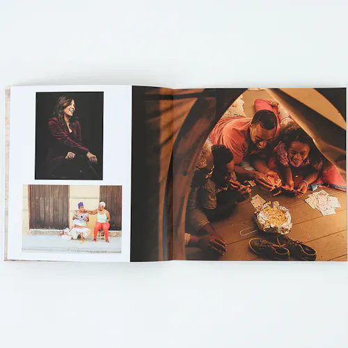 A photo portfolio laying open to images of a family eating popcorn in a tent and two people sitting on the street.