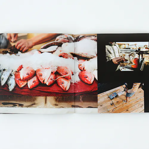 ©Roy Son Photo A photography booklet laying open to images of fish on ice and a person standing on a fishing dock.