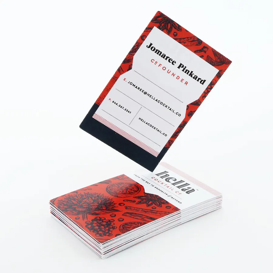 A stack of unique business cards with a red, black and white design and one card standing on the stack.