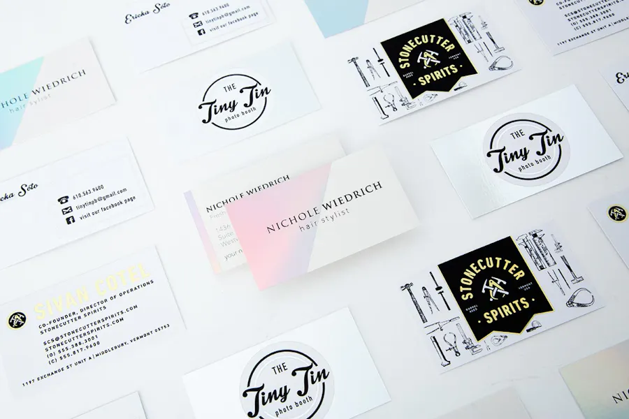 An array of unique business cards lined up in rows with gold foil, silver foil and holographic foil accents.