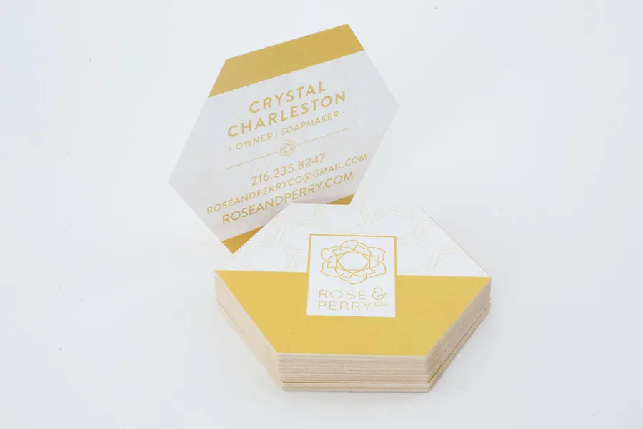 A stack of unique business cards printed in a hexagon shape with a yellow and white design.