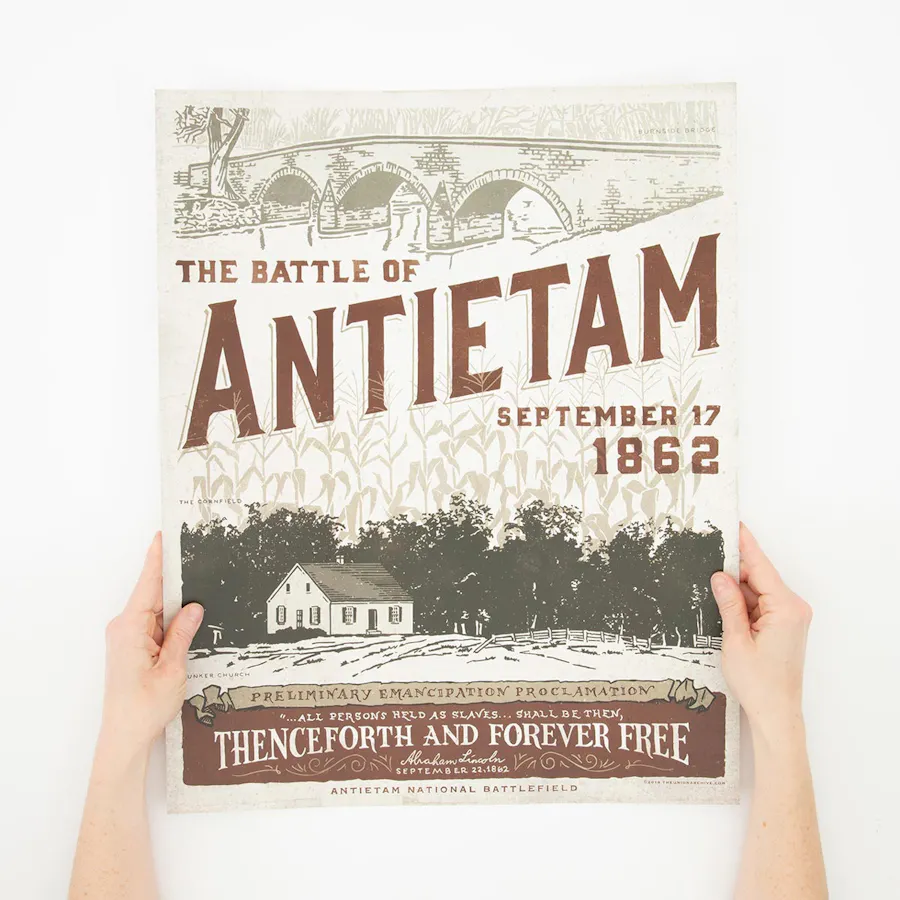 Two hands holding a custom small poster with The Battle of Antietam and September 17 1862 in dark red color.