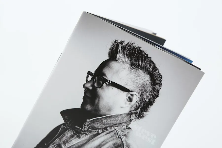 A custom photography book with a black and white image on the front of a person with a mohawk and glasses.