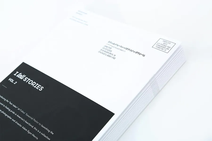 A stack of direct mail booklets with a saddle stitch binding and a black and white design.