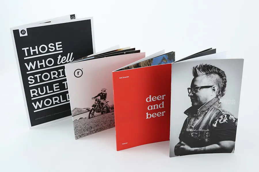 Four photography booklets printed with a saddle stitch binding standing in a row.