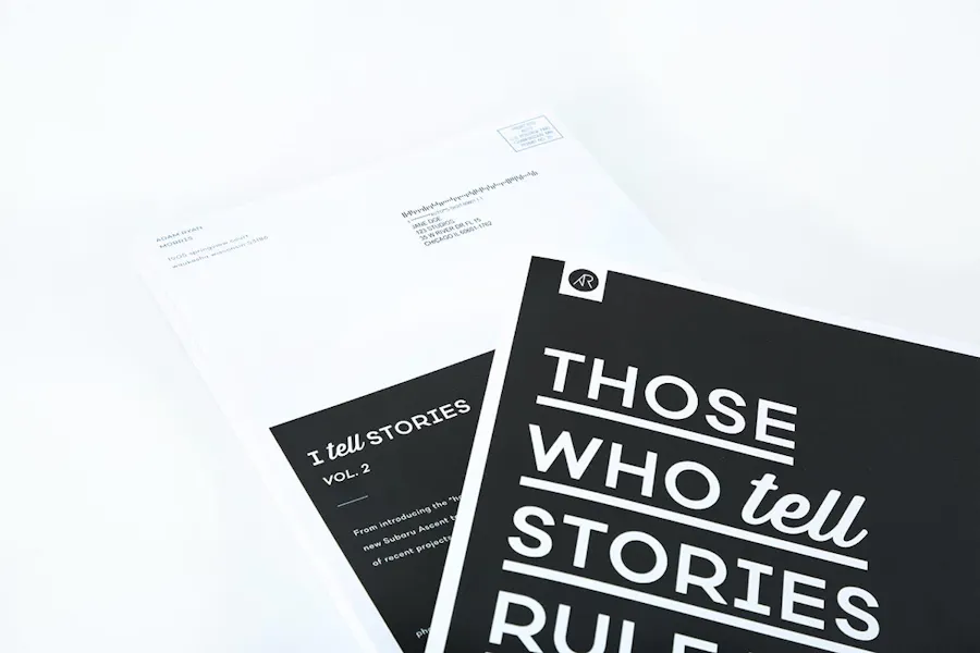 Two direct mail booklets with a black and white design and Those Who Tell Stories underlined on the front.