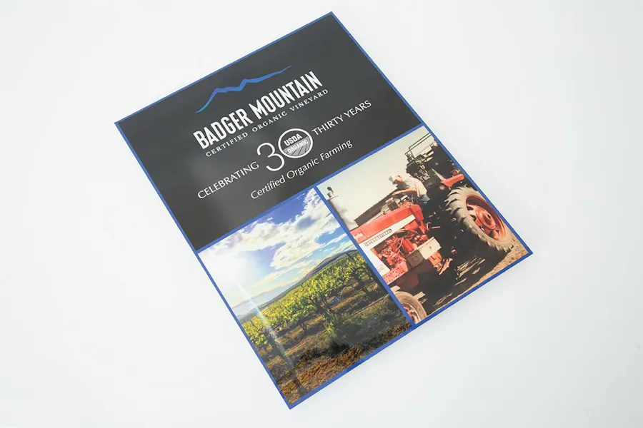 A winery marketing flyer printed with Badger Mountain at the top and images of a vineyard and tractor.