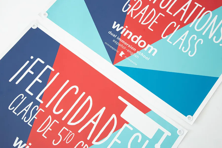 Two school posters printed with a blue, teal and red design and graduation information.
