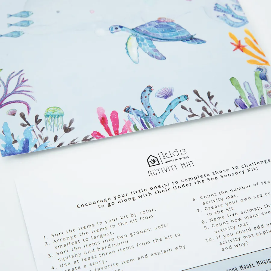 Night In Boxes activity mats printed with instructions on one side and an underwater scene on the other side.