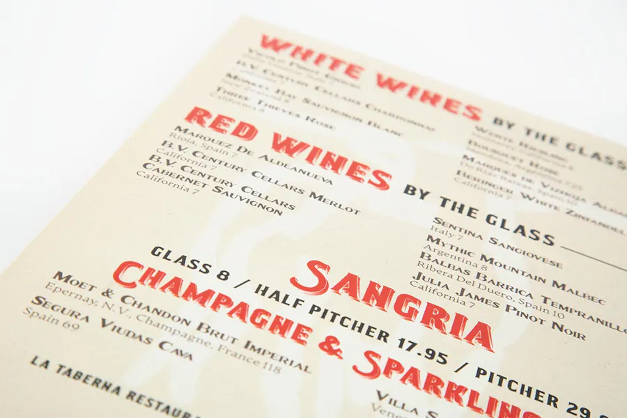 A custom menu printed with wine and sangria options in red and black text.