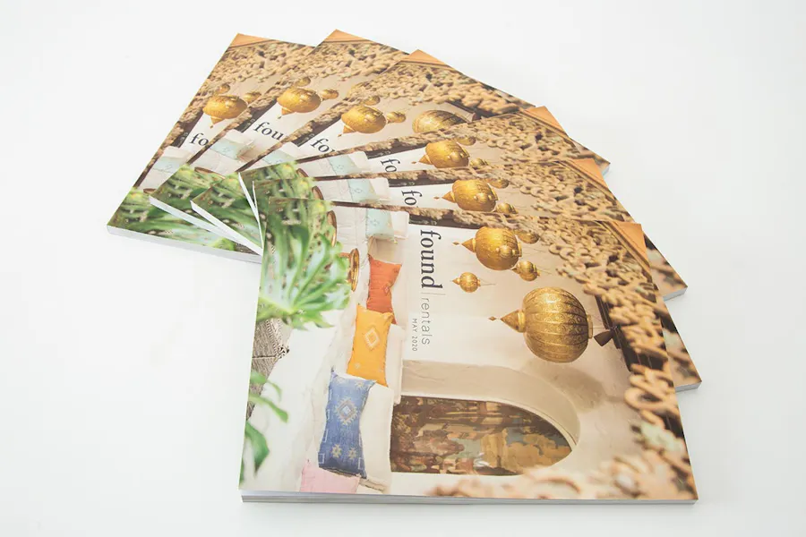 Fanned-out product lookbooks with found rentals and an image of an outdoor seating area with gold lamps.