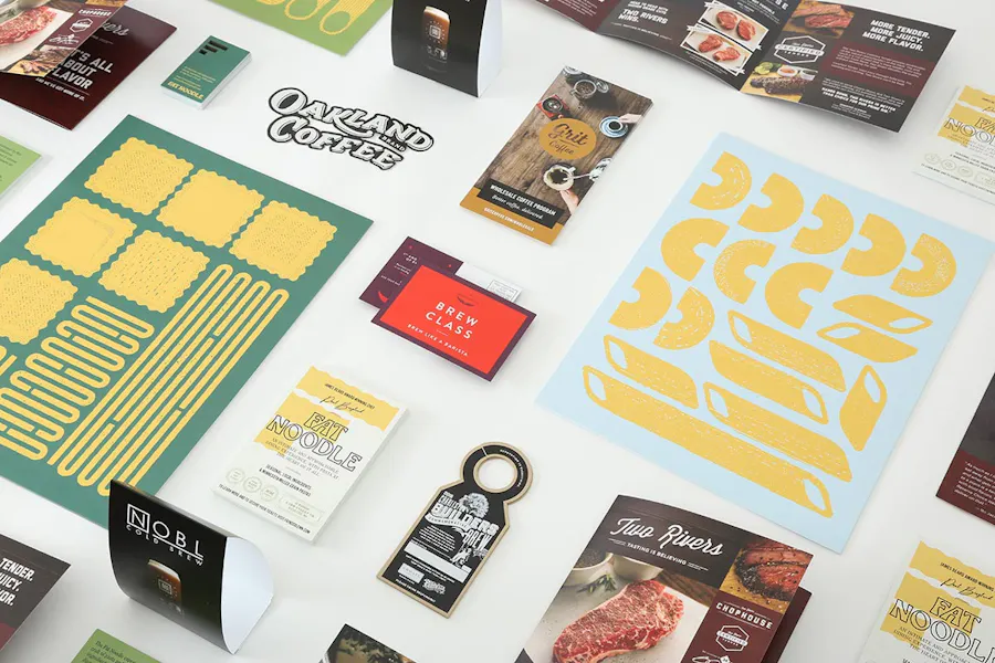 An array of restaurant marketing pieces, including posters, brochures, table tents, menus and business cards.
