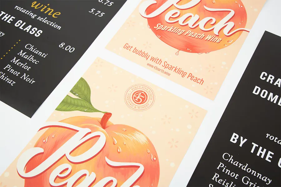 Two custom posters with a peach and Sparkling Peach Wine between two winery menu posters.