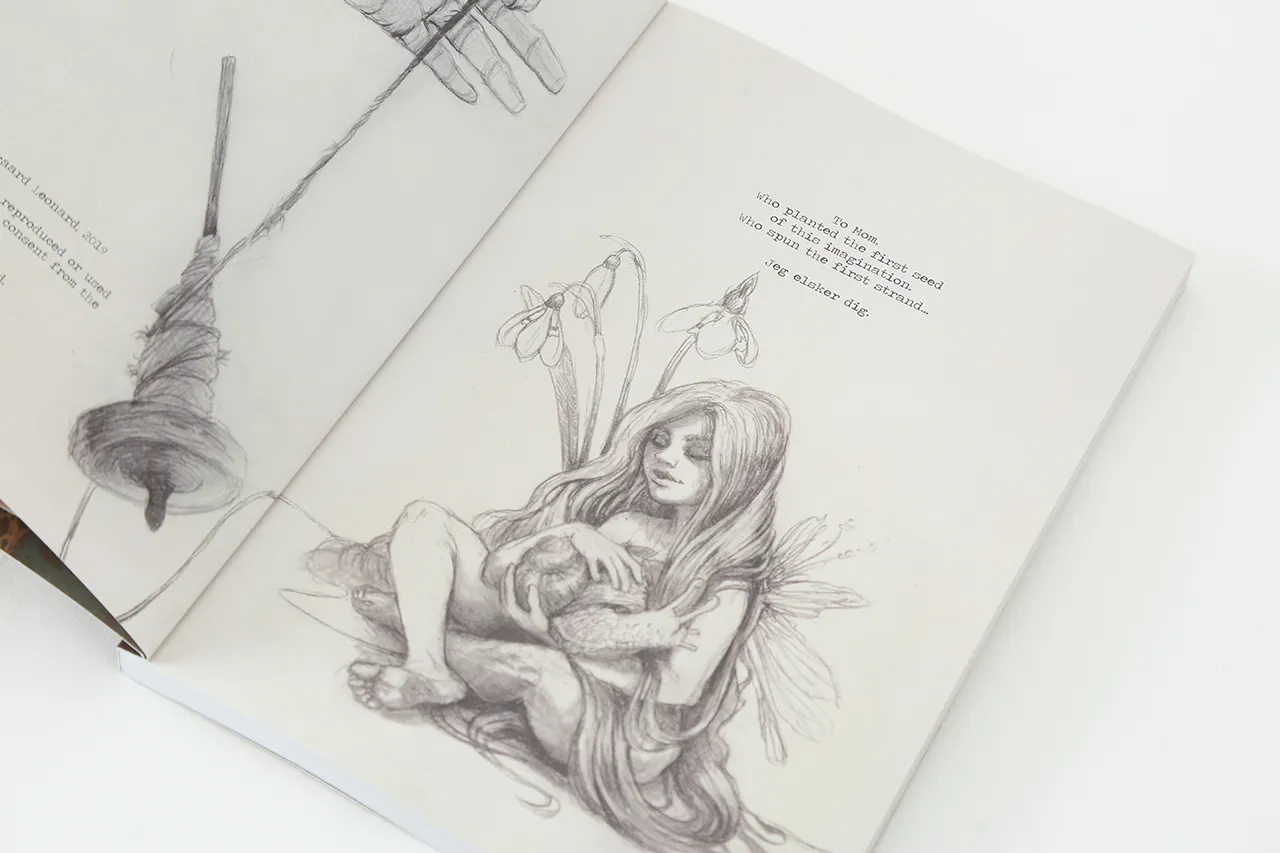 A sketchbook laying open to an illustration of a girl with very long hair sitting among flowers and holding a snail.