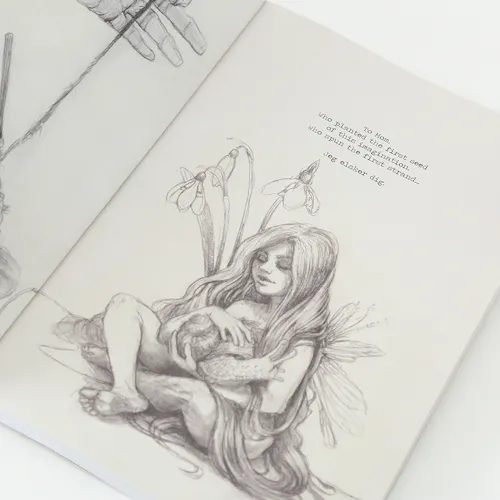 A sketchbook laying open to an illustration of a girl with very long hair sitting among flowers and holding a snail.