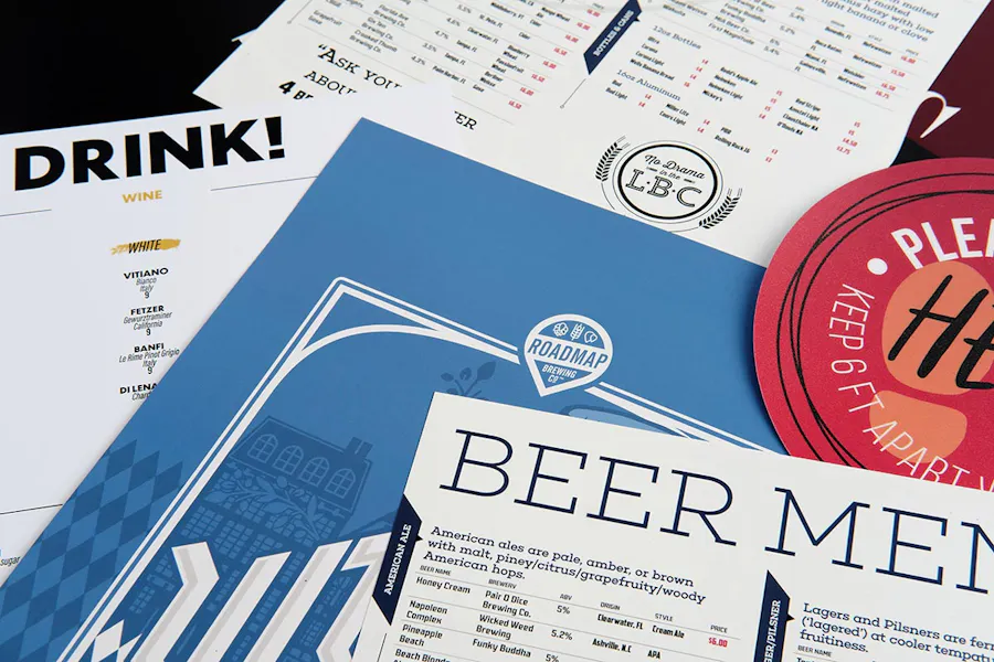 Brewery marketing materials overlapping each other, including menus, decals and posters.