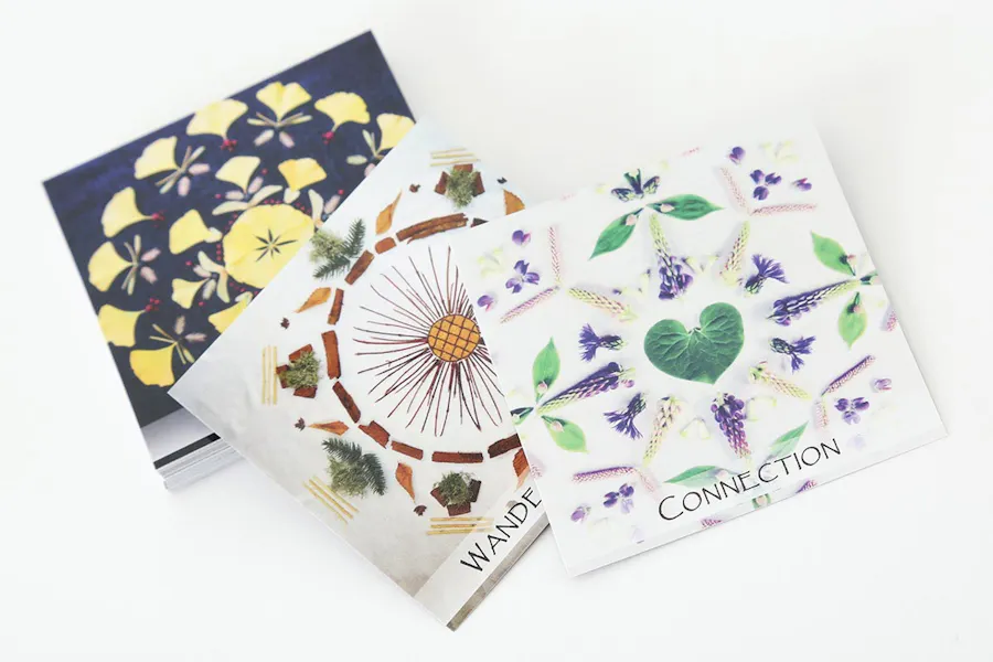 Three cards printed with nature mandalas in various colors and designs.