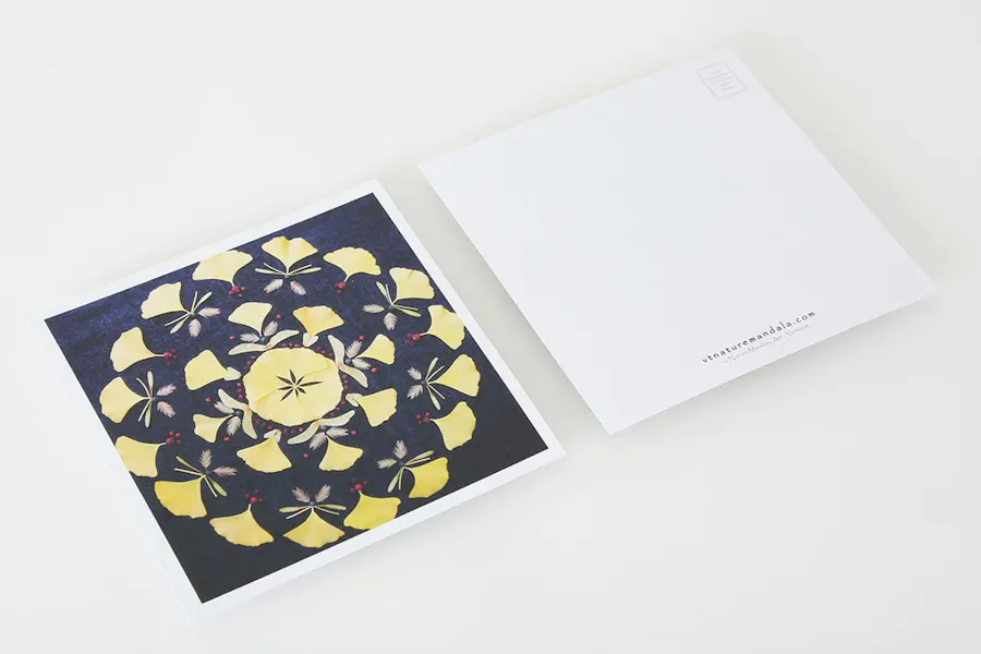 Two custom postcards printed with a floral mandala on the front and contact info and postage on the back.
