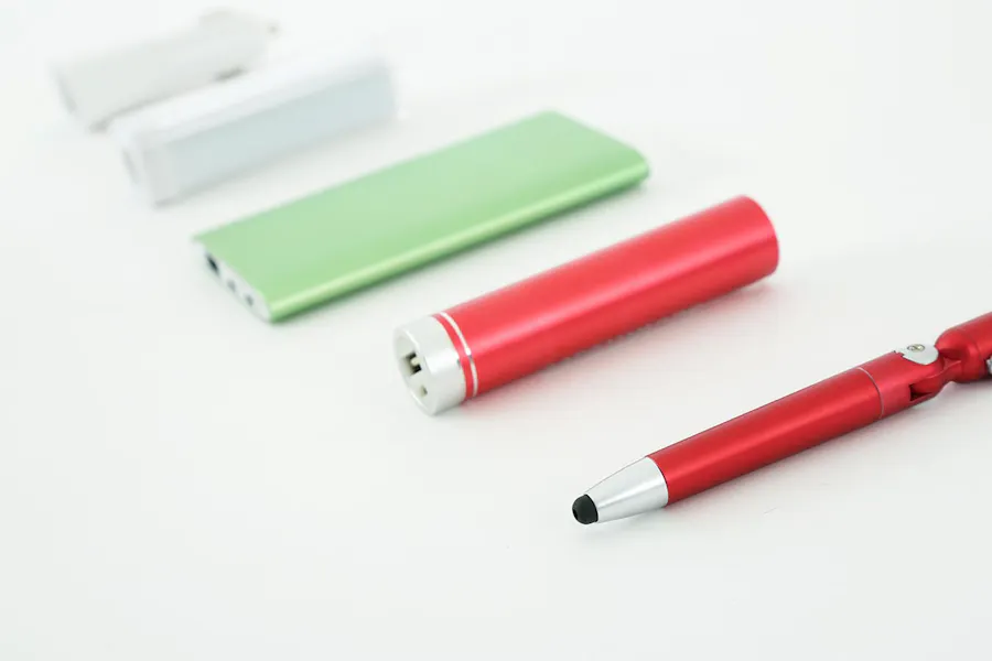 Electronic promo items lined up in a row, including a stylus pen and USB chargers in red, green and white.