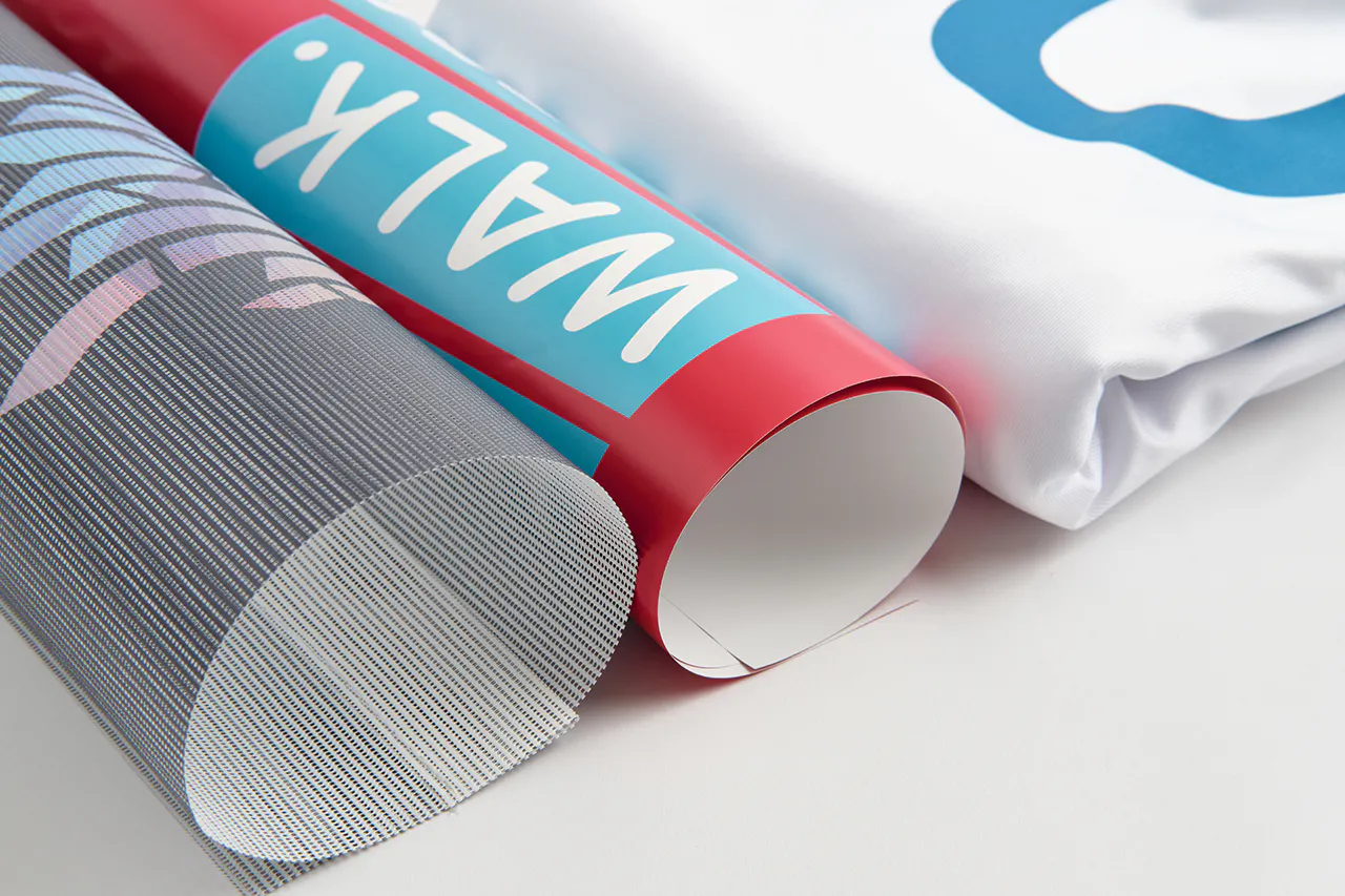 Three rolled-up banners printed with red, white, blue and gray designs and Walk in white text on the one in the middle.