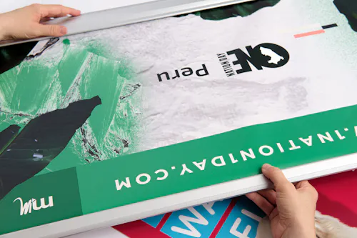 Two hands unrolling a custom retractable banner printed with One Nation Day Peru in green, white and black.
