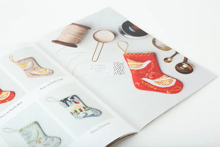 A holiday catalog laying open to images of custom stockings and measuring cups.