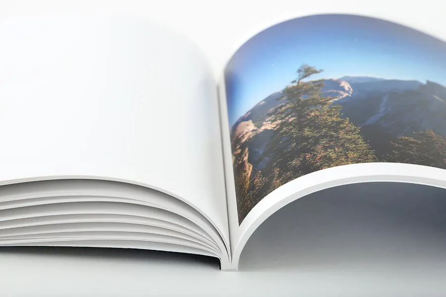A photography booklet laying open to an image of a mountain landscape.