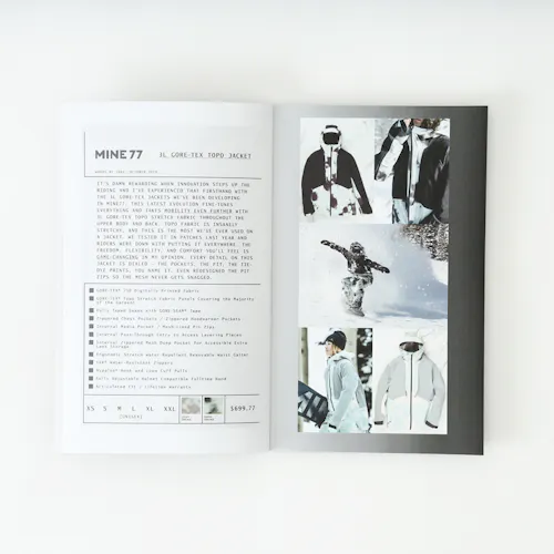 A Mine77 lookbook laying open to images of a snowboarding jacket and details about it.