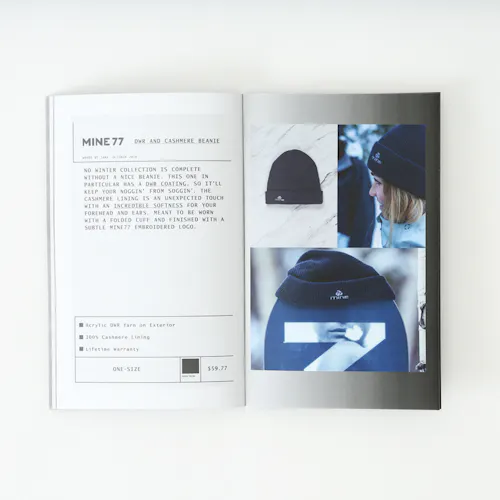 A Mine77 lookbook laying open to images of a cashmere beanie and details about it.