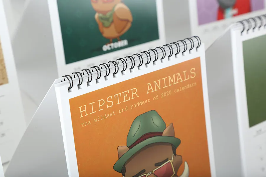 Custom wire bound calendars printed with Hipster Animals on the front lined up in two rows.