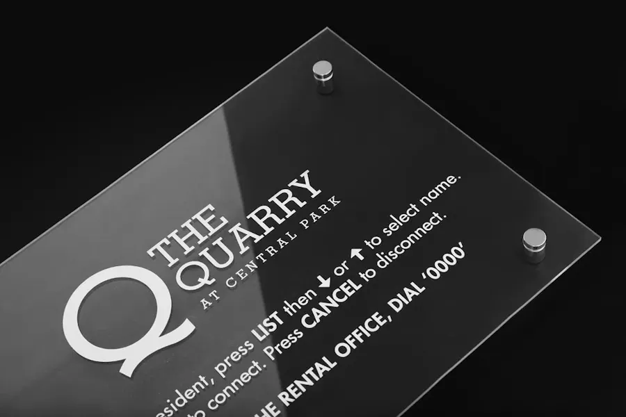 A business sign printed on clear acrylic with "The Quarry at Central Park" in white text.