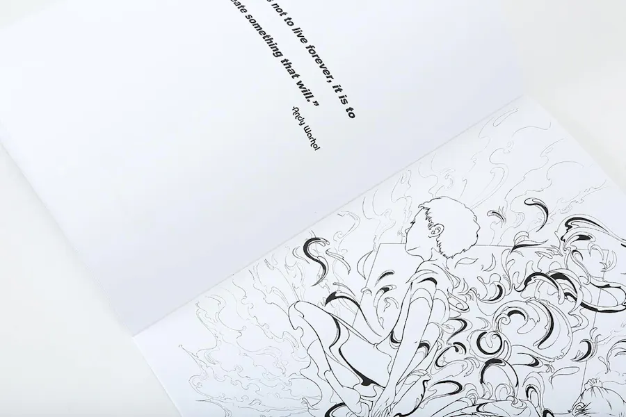 A custom coloring book laying open to a black and white graphic and a quote from Andy Warhol.