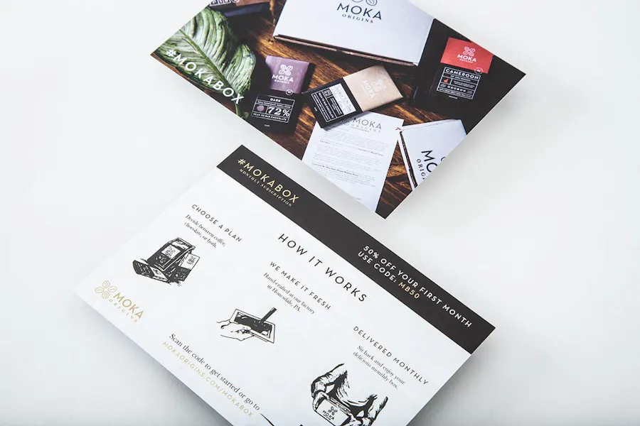 Two package inserts printed with subscription box information and images of chocolate bars.