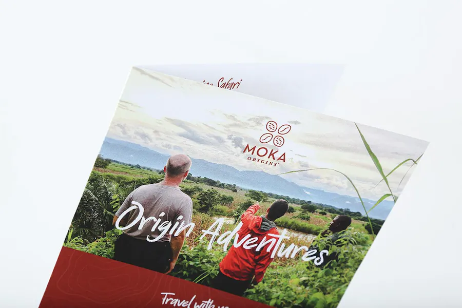 A custom brochure printed with Moka Origins and an image of three men standing in a field.