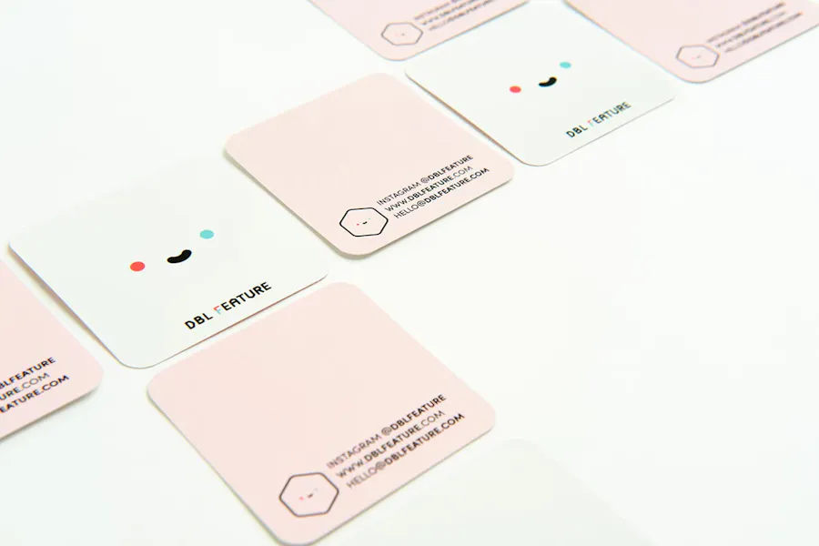 Unique business cards that are also pin backers with a square design lined up in a row.