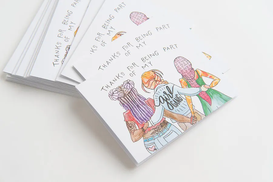 A stack of custom cards printed with a design featuring three girls holding hands.