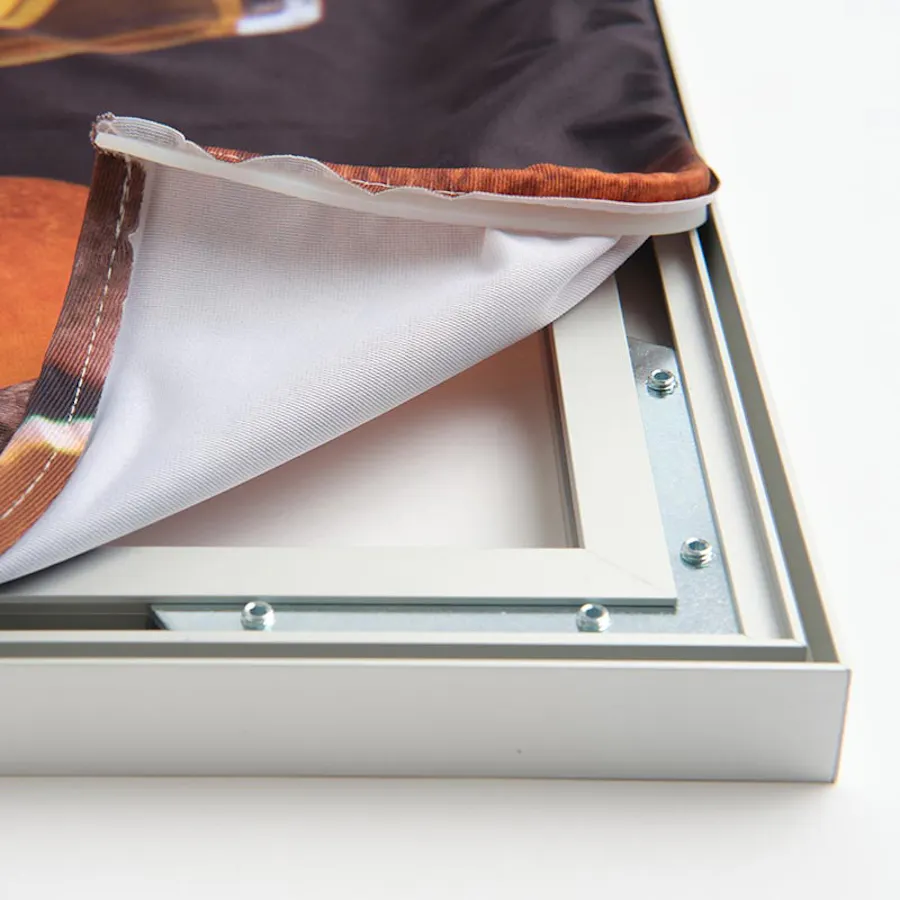 The corner of an SEG wall graphic with the printed fabric folded back, revealing the underside of the aluminum frame.