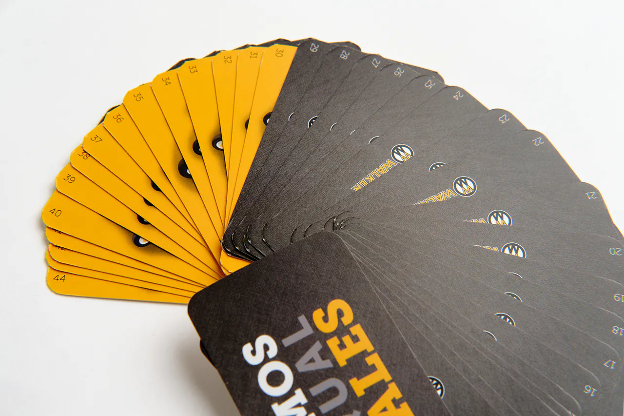 A stack of Walker Mower product flashcards fanned out in a circle with a black and yellow design.