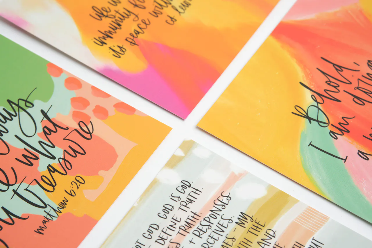 Four devotional cards printed with verses in black text and watercolor background in orange, pink, yellow and green.