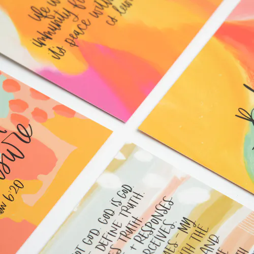 Four devotional cards printed with verses in black text and watercolor background in orange, pink, yellow and green.