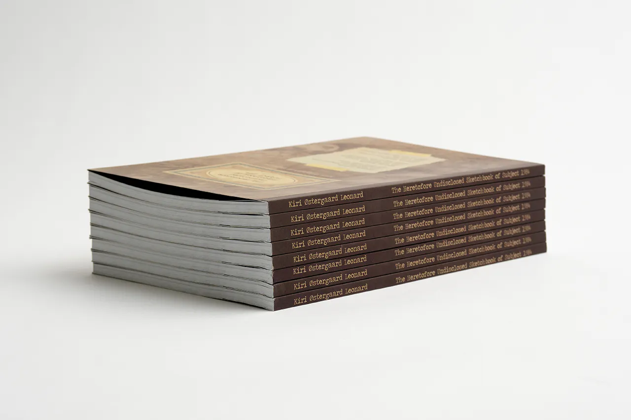 A stack of custom printed sketchbooks with Kiri Ostergaard Leonard and the title on each spine.