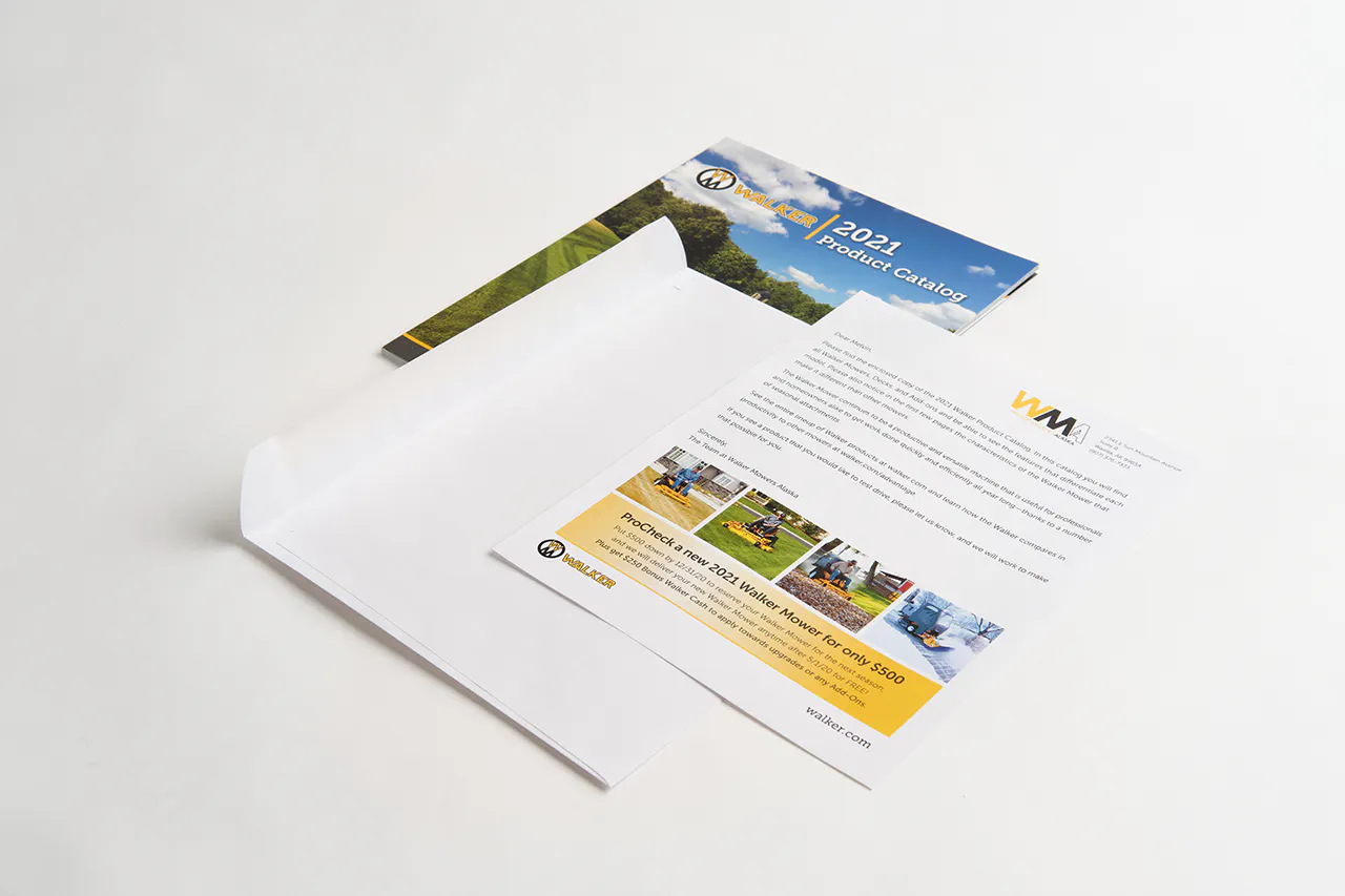 A Walker Mower product catalog and marketing flyer laying next to a plain white envelope.