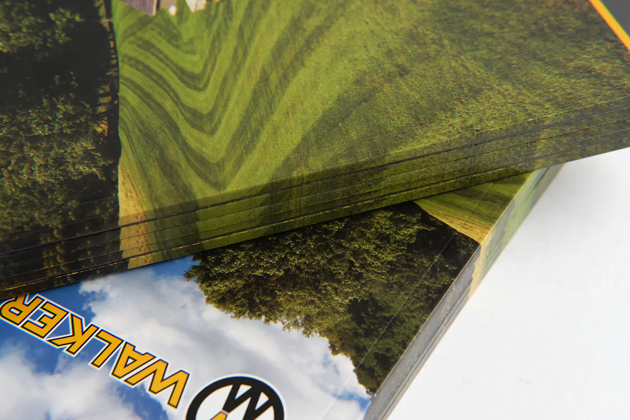 A stack of Walker Mower product catalogs with a perfect binding and bright green grass on the covers.