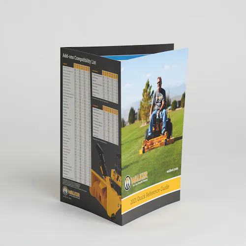 A Walker Mower product brochure standing open with a man on a riding mower on the front and a comparison list on the back.