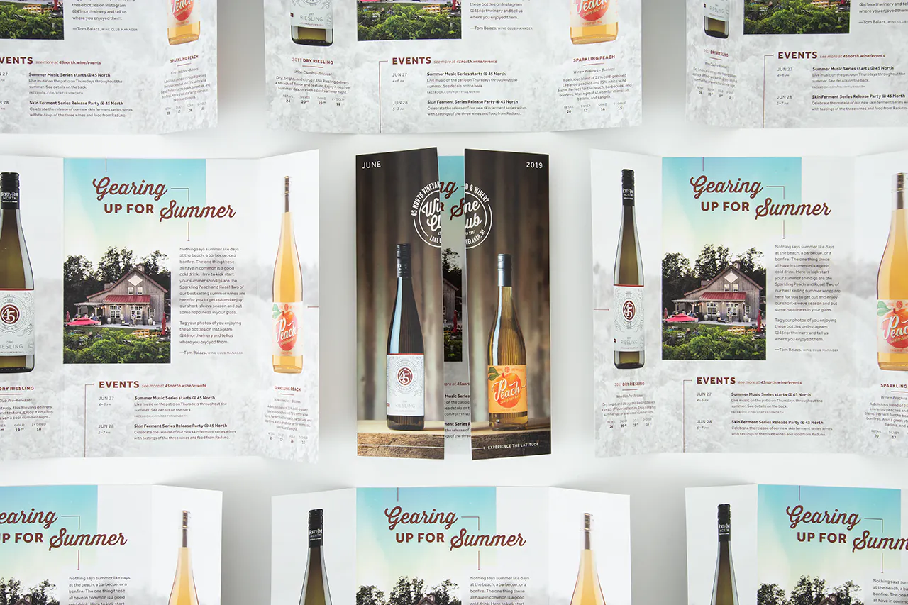 A custom brochure with a gate fold and images of wine bottles surrounded by more unfolded brochures with wine information.
