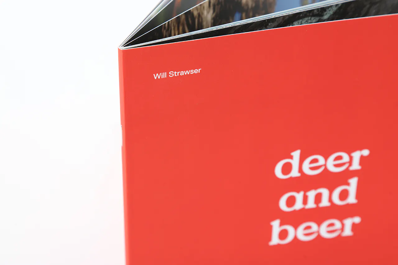 A marketing booklet standing open with a red cover and white text on the front.