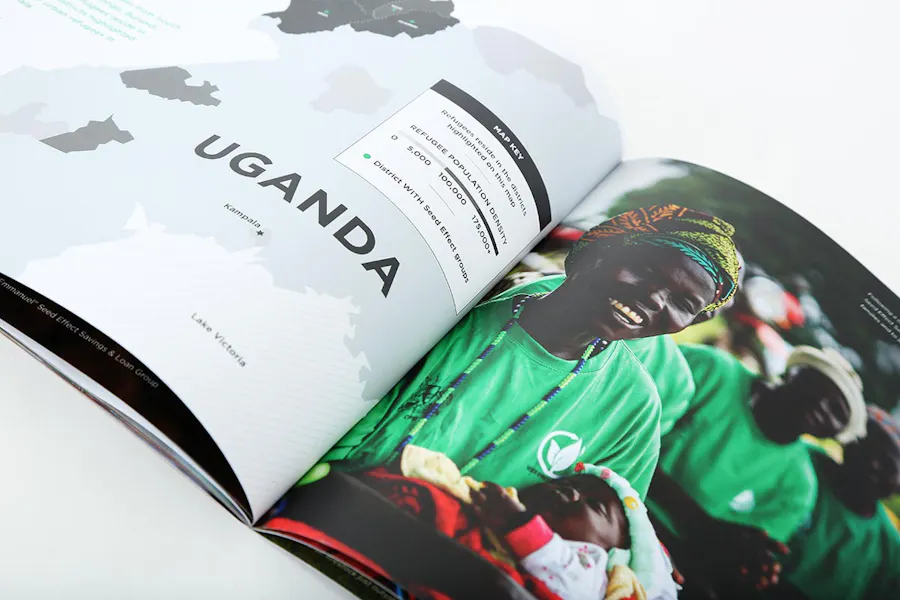 A saddle stitched annual report laying open to a map of Uganda and an image of a smiling woman holding a baby.