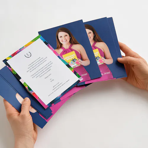 POSTCARD: 80# COATED MATTE WHITE COVER, 4 x 6" Two hands holding fanned-out postcards printed with a woman in a pink dress and a welcome note.