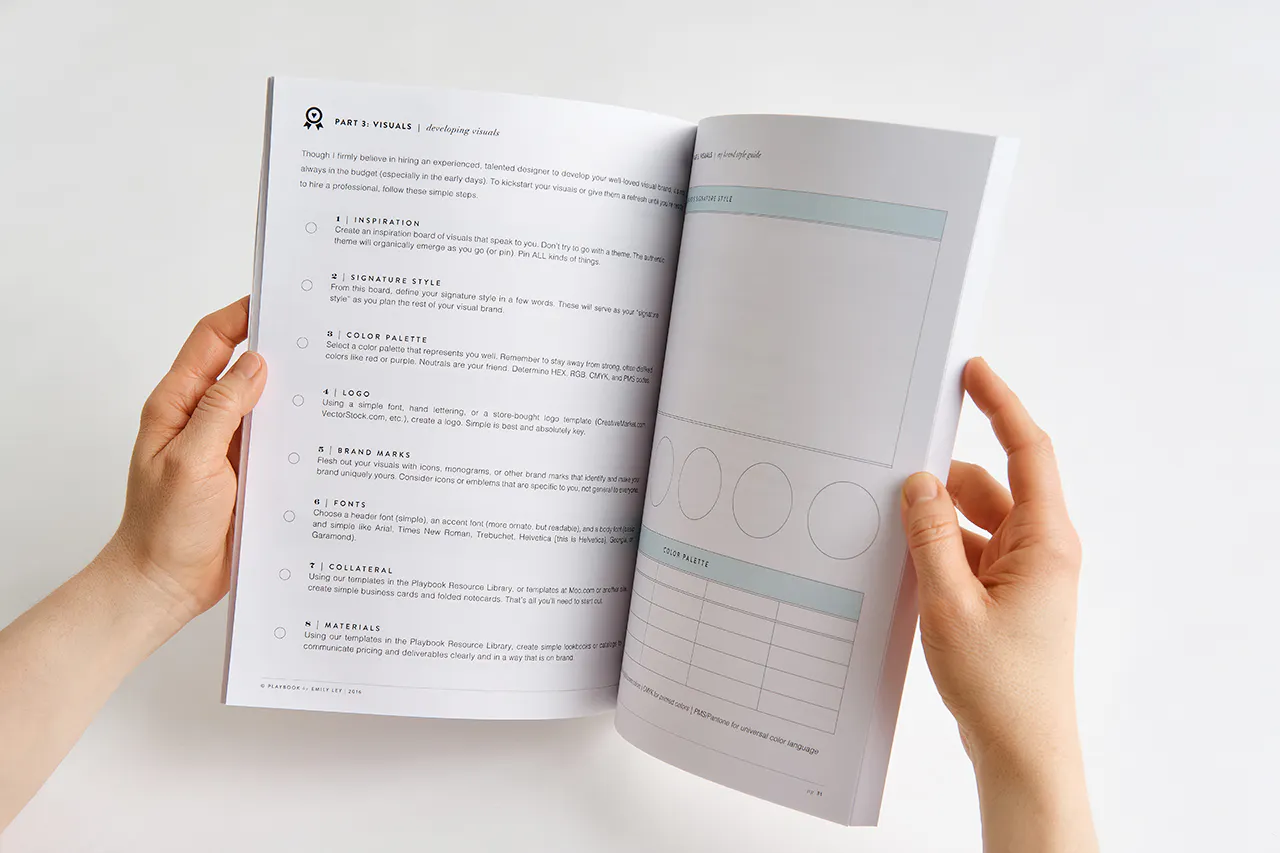 Two hands flipping through a marketing workbook printed with information about brand visuals.