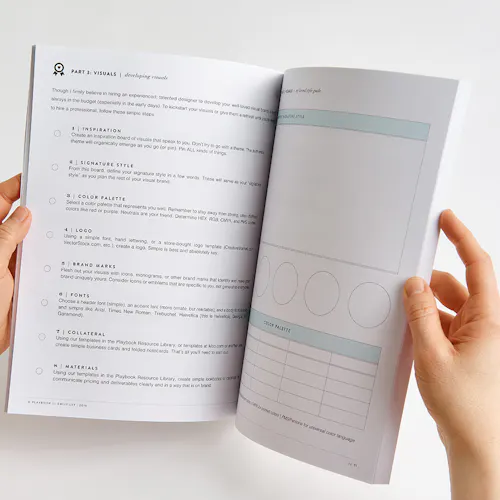 Two hands flipping through a marketing workbook printed with information about brand visuals.